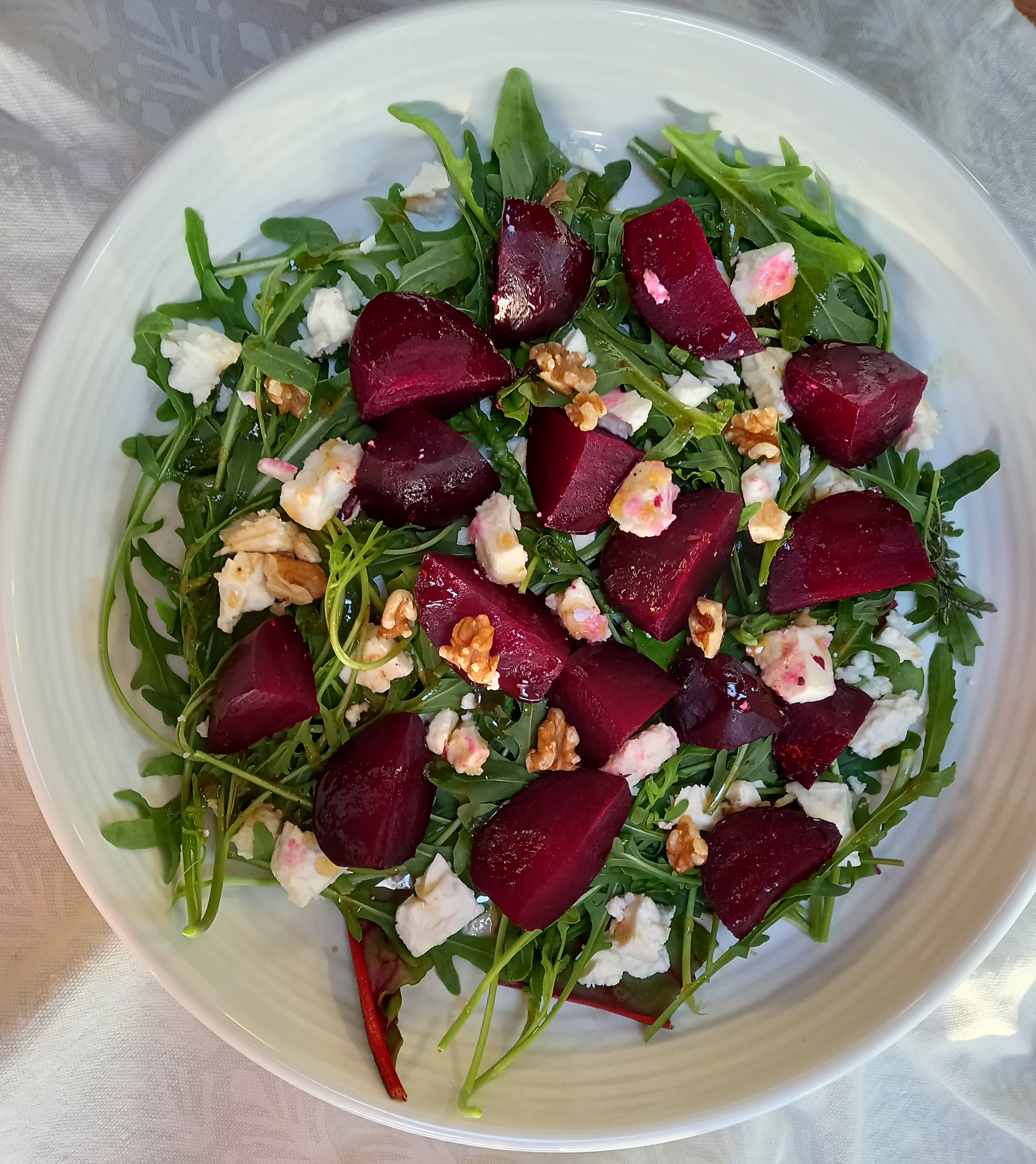 chopped beetroot with white cheese on bed of greens