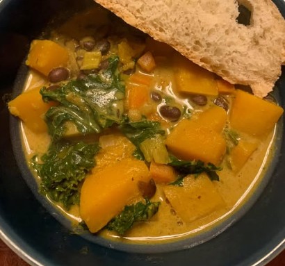 squash black bean soup in bowl with white bread on side