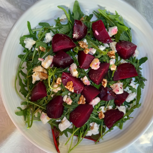 chopped beetroot with white cheese on bed of greens