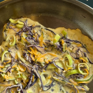shredded vegetable pancake in frying pan